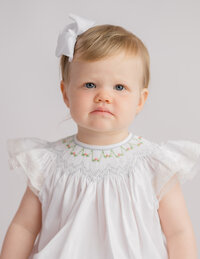 Heirloom Photographer in Charleston - Baby looks at the camera during Heirloom Photoshoot at Holy City Babies Portrait Studio in Charleston, SC.