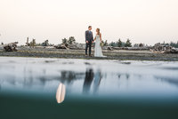 Wedding couple with their reflections on the ocean