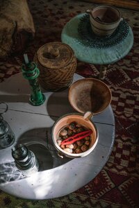 Light hitting a bowl of walnuts in an overhead interior scene of artisan homeware on a patterned rug