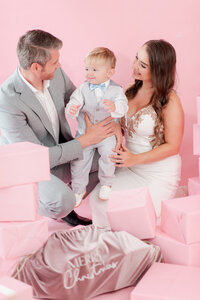 family of three in a pink christmas editorial set for Miami Christmas Mini Sessions