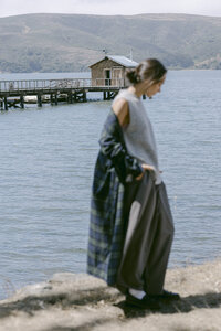 Grey knit tank and grey skirt with a plaid layer, shot at the water's edge