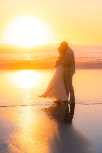 sunset beach couple embracing on sand barefoot in santa cruz.