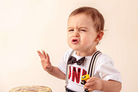 close up of toddler with frosting on face during cake smash session