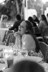 A wedding guests laughs during candle lit wedding reception on Nantucket.