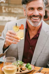 Guest with a cocktail and tacos on the patio at Mustangs & Burro