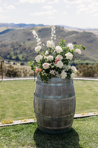 Close up florals on a wine barrel used as arbor decor for a wedding at Brindabella Hills Winery. Floral arrangement by Sunshine Events