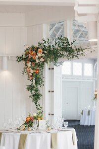 Elegant wedding reception with large floral installations captured with an editorial photography approach
