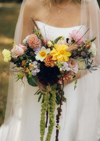 Vibrant bridal bouquet with pink, yellow, and orange flowers by Flowergirl Cville, Charlottesville wedding florist, for Keswick Vineyard wedding | Photo by Abby Hart Photography