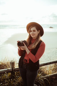 Portrait of Morgan Wright holding a camera on the Oregon Coast.