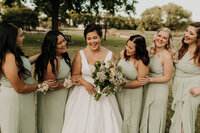Bride and bridesmaids hugging and laughing