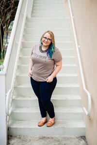 Mahlia standing on stairs wearing a Strawberry Revolution shirt