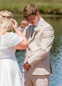 Bride and Groom having their emotional first look by the lake at Brightwater weddings and events.