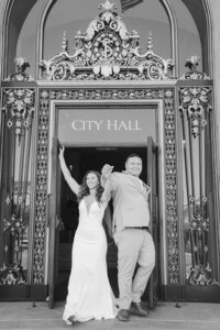 bride and groom celebrate in front of san francisco city hall doors