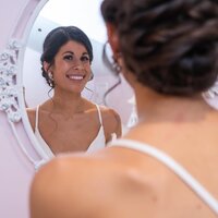 bride admiring her hair and makeup before wedding