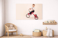 toddler on vintage tricycle in studio portrait canvas hanging on wall in New Bern home