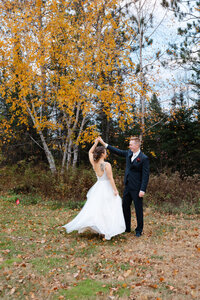 Groom twirls his new bride after a fall ceremony at Giants Ridge