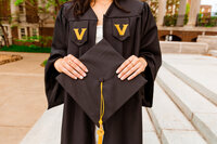 Detail photos of Vanderbilt senior wearing gown and holding cap