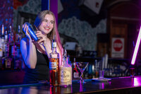 A bartender mixing a drink in a shaker