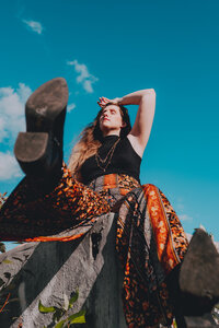 Creative portrait of Morgan Wright seated against a bright teal backdrop.