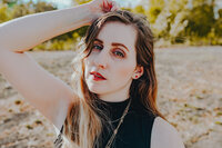 Close-up outdoor portrait of Morgan Wright surrounded by greenery.