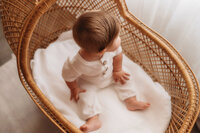 Baby posed in an antique basinet during Baby Milestone Portrait Session at Holy City Babies Portrait Studio in Charleston, SC.