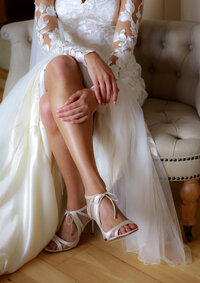 Bridal detail of wedding shoes and satin dress