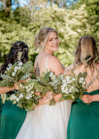 Bridal party portraits with the bride looking over her shoulder at the camera at the Abernethy Center in Oregon City.