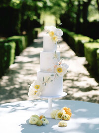 An editorial-style portrait of a three-tiered floral wedding cake, showcasing refined composition and intentional imagery.