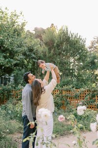 Couple holding their baby up and looking at him lovingly during their family session at Gamble Gardens in Palo Alto
