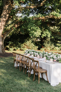Outdoor wedding table with wooden chairs and lush florals in wedding photography Detroit MI