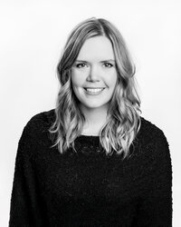 Black-and-white-headshot-of-woman-with-blonde-hair-and-black-sweater