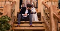 Yulee wedding capturing a tender pre-ceremony moment as the groom sits on the staircase with the couple’s white dog in bridal florals, their foreheads nearly touching as the bride stands just beyond. - A portrait experience by Nature's Child Photography.