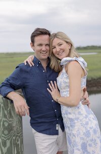 Couple in blue shirt and floral dress look to the camera during Nantucket engagement session.