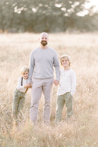 A photo of a dad and his two sons standing in a local Frisco TX park.