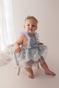 Baby gazes at the camera during her 1st birthday photoshoot at Holy City Babies Portrait Studio in Charleston, SC.