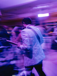 Artistic motion-blur photograph of a live guitarist at a high-end wedding reception, capturing the movement and energy of the night.