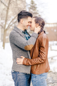 A couple come close for a kiss on a winter's day during their engagement session.
