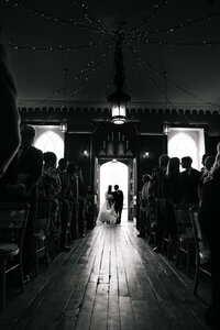 The brides entrance to her ceremony at tawstock court captured by a colourful candid wedding photographer