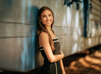 Senior portrait in downtown Foley, Alabama — close-up headshot near the blue train car.
