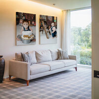 Bright living room featuring framed cake smash portraits of a one-year-old baby, Kaitlyn Dawn Photography, Yucaipa milestone and family photographer.