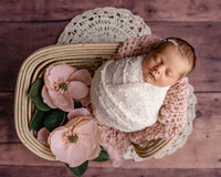Newborn baby girl posed with magnolia flowers during a Louisiana newborn photography session