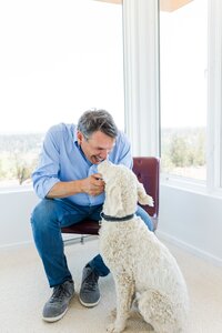 Branding photo of a Bend Oregon professional interacting with his dog during an indoor session