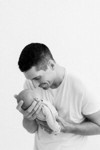 Dad holding newborn baby at a newborn photography session in Salem, OR.
