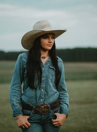 Senior portrait at Triple T Farms in Fruitdale, Alabama — waist-up, thumbs in pockets, looking
off into the distance.