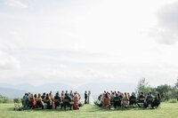 Wedding attendees stand as bride and groom meet at the altar