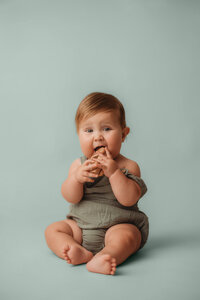 Charleston Baby Milestone Photographer - Nine Month old baby teeths on a wooden car during a Baby Milestone Photoshoot in Charleston, SC.