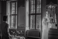 Mariée ajustant son voile près d'une haute fenêtre à petits carreaux, boiseries sculptées et miroir ancien, lumière naturelle et fleurs blanches, préparatifs au Ritz-Carlton, Montréal