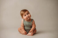 Baby looks curiously at the camera during Baby Milestone Portrait Session at Holy City Babies Portrait Studio in Charleston, SC.