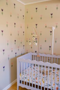 Pink nursery with Scandinavian floral design and scalloped crib