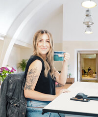 Portrait of brand designer Jenna Balogh smiling in her Austin, Texas workspace